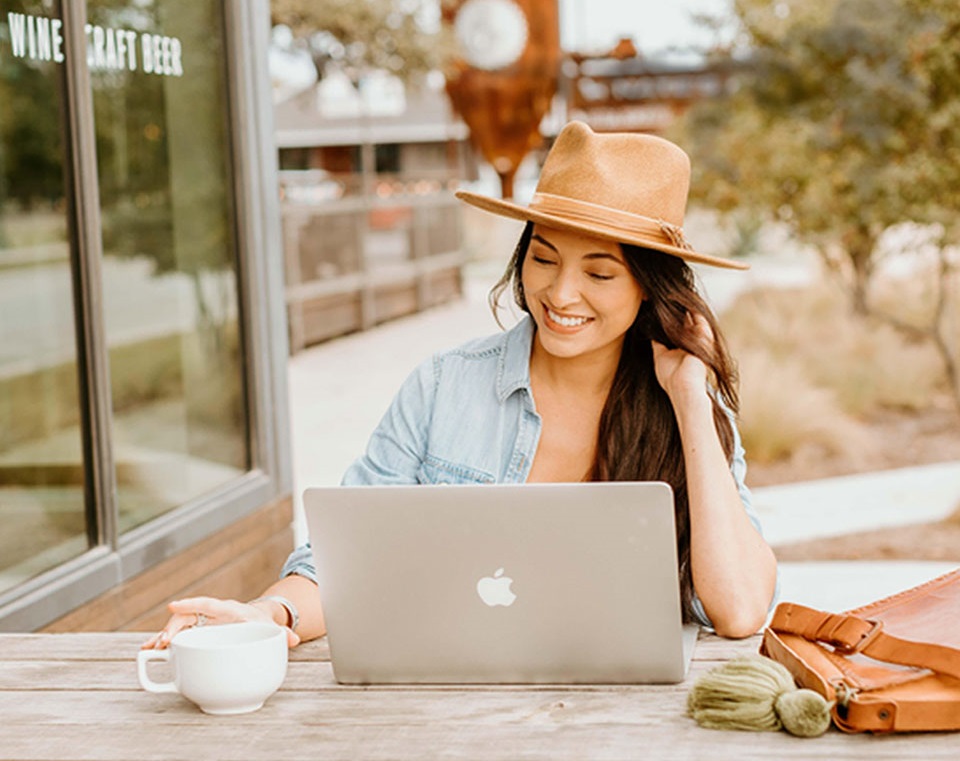 Buda Mill & Grain Co. Woman with laptop and coffee
